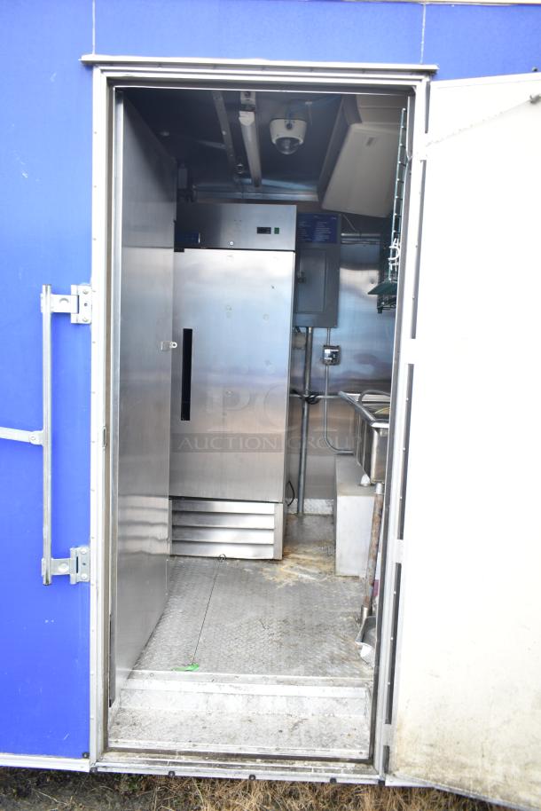 Fully outfitted mobile kitchen trailer interior with CaptiveAire hood, prep tables, Arctic Air cooler, and fryer setup.