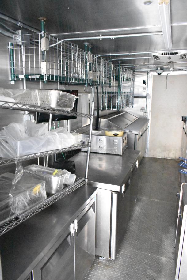 Fully outfitted mobile kitchen trailer with CaptiveAire hood, Pitco fryers, Arctic Air prep tables, coolers, and freezers.