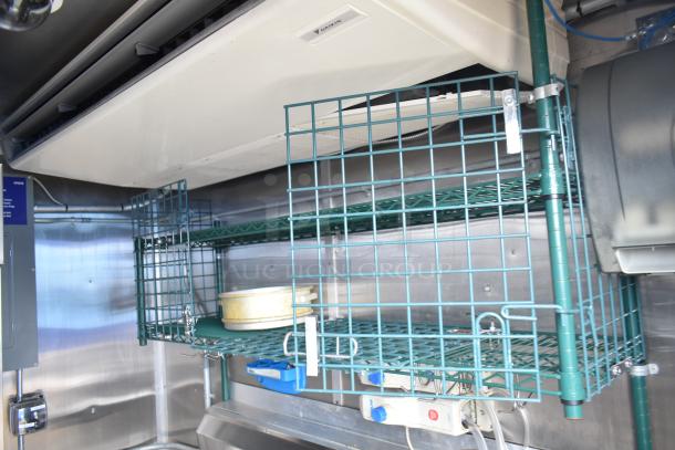 Fully outfitted mobile kitchen trailer interior with CaptiveAire hood, Daikin air system, shelving, and POS equipment.