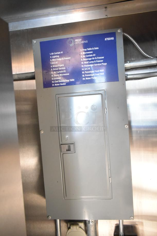 Electrical control panel in a mobile kitchen trailer, labeled with equipment list including CaptiveAire hood, Pitco fryers, and Arctic Air units.