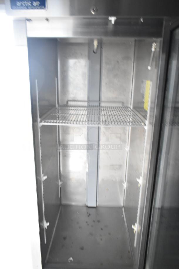 Interior of Arctic Air cooler in mobile kitchen trailer, showing an empty steel shelf. Minimal wear visible.