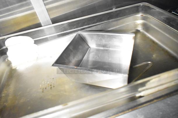 Stainless steel interior of a fully outfitted mobile kitchen trailer with CaptiveAire hood and Pitco fryers, showing clean metal surfaces.