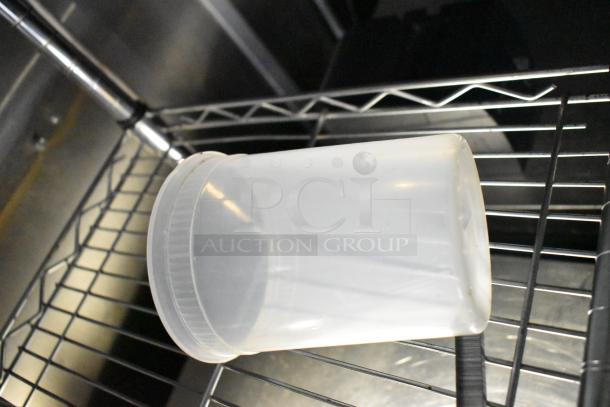 Plastic container on metal wire shelf inside mobile kitchen trailer.