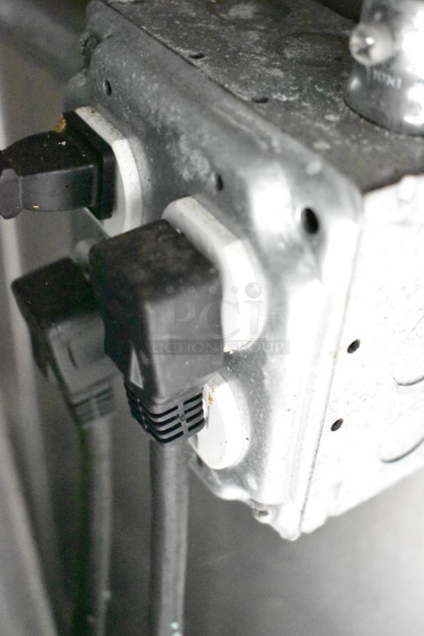 Electrical outlets with plugged-in cables inside a mobile kitchen trailer, part of the full POS infrastructure.