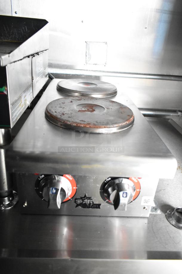 Stainless steel countertop with double hotplates and Star Max control knobs in mobile kitchen trailer.
