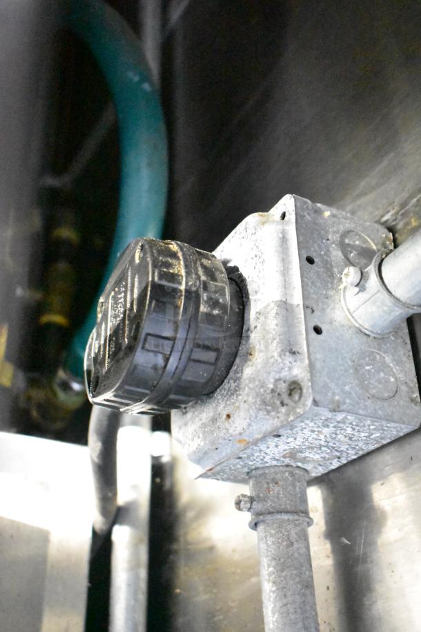 Mobile kitchen trailer detail showing an electrical conduit and weathered black cap on a metal junction box.