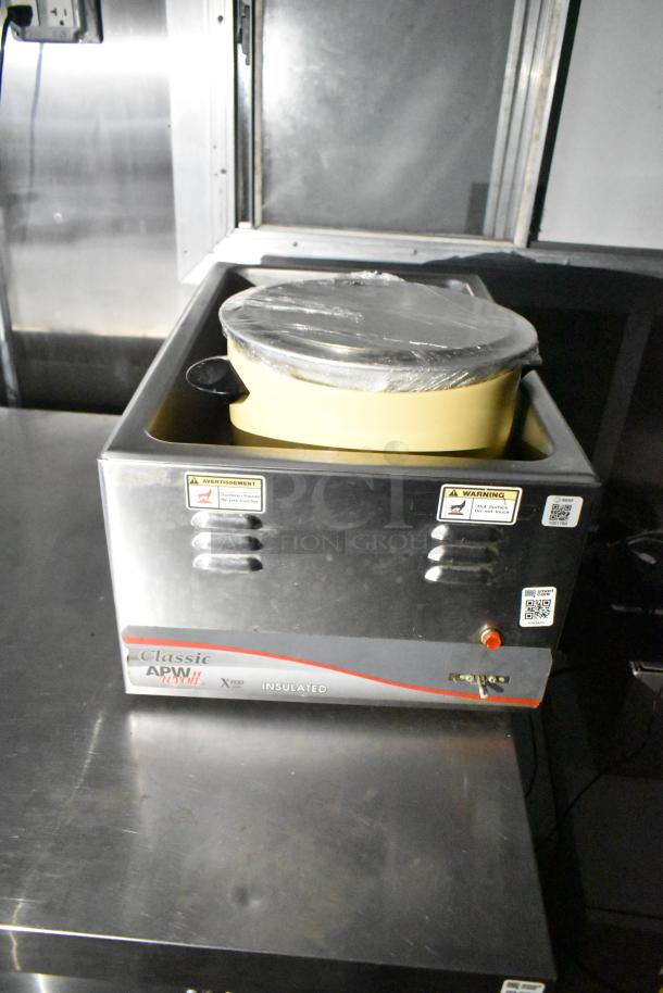 Insulated APW Wyott Classic soup warmer, stainless steel, with warning labels, in a mobile kitchen trailer setting.