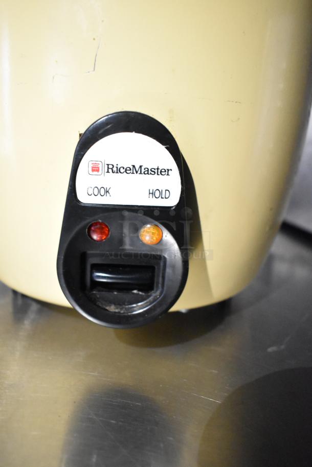 RiceMaster rice cooker with "Cook" and "Hold" settings, two indicator lights, and a beige exterior.