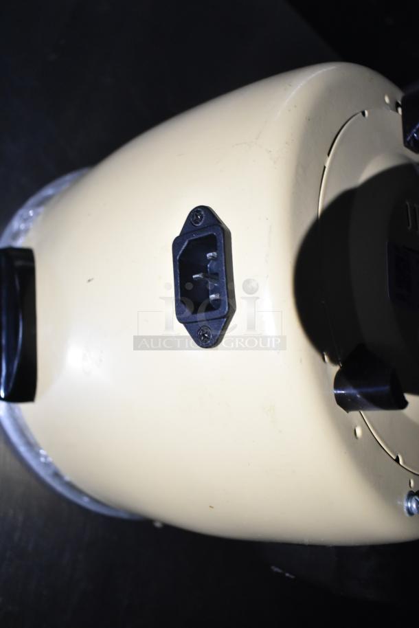 Portable appliance with power socket, beige casing, and black handle, suggesting a kitchen equipment component. Condition appears used.