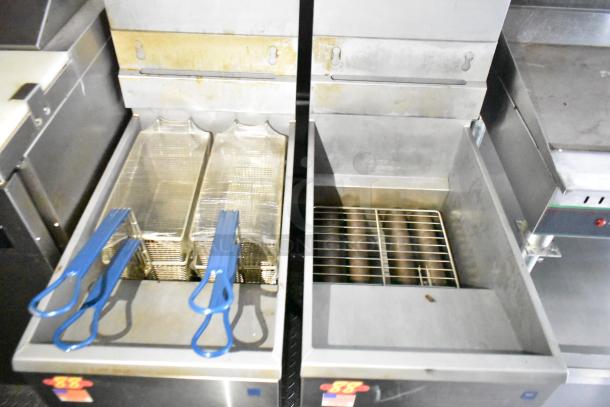 Fully outfitted mobile kitchen trailer showing dual Pitco fryers with blue-handled baskets, showing light wear.
