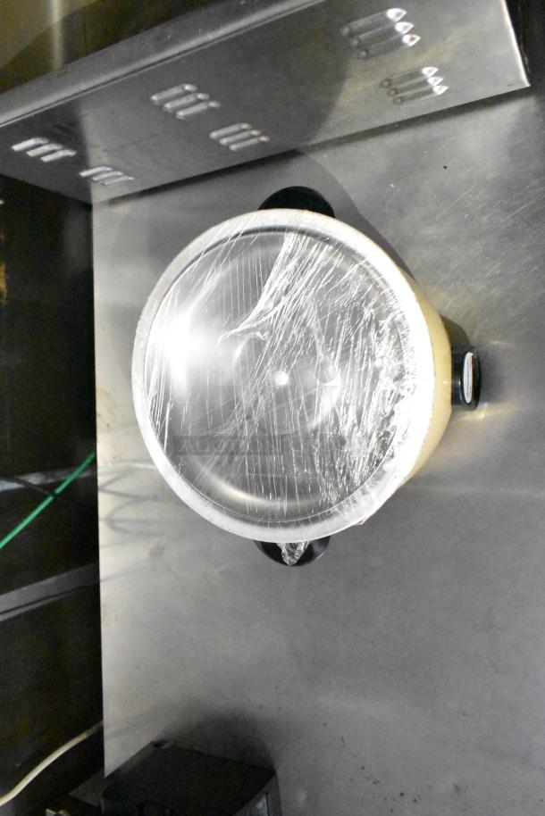 Mobile kitchen trailer interior showing a wrapped CaptiveAire hood and metal fixtures.