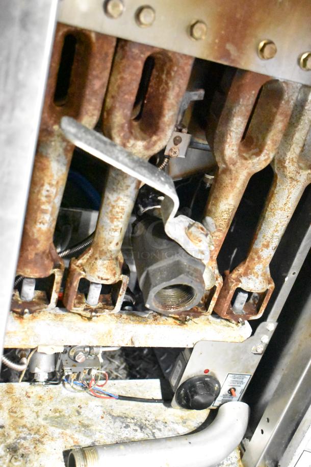 Interior view of a mobile kitchen trailer with visible CaptiveAire hood components. Rust and wear present on metal parts.