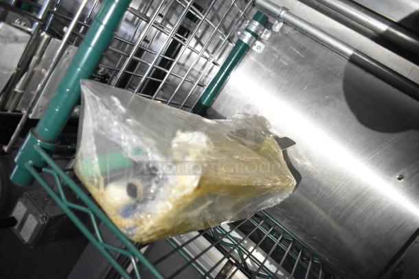 Plastic-wrapped item on green wire rack inside mobile kitchen trailer. Part of outfitted setup with CaptiveAire hood and Pitco fryers.