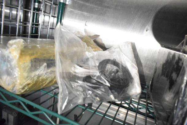 Alt text: Mobile kitchen trailer interior with packaged equipment and cables on metal shelving.