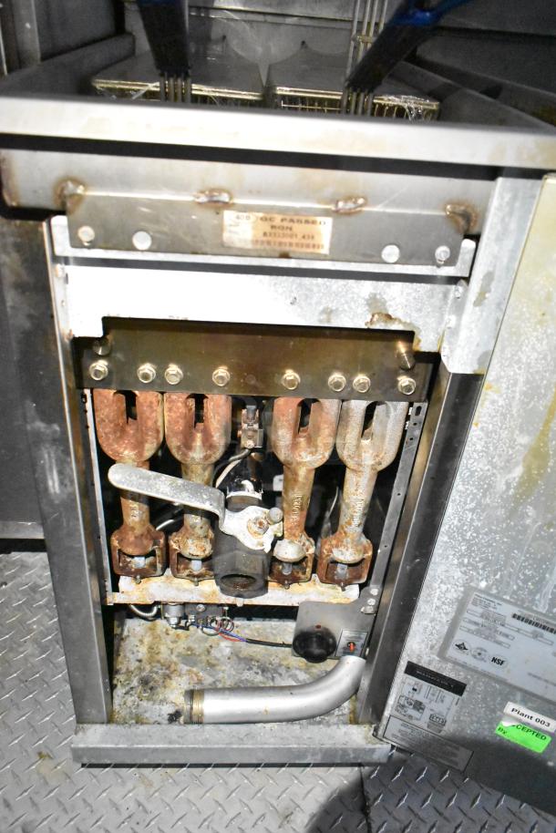 Mobile kitchen trailer component, showing metal piping and heating elements. Tags and labels indicate inspection approval.