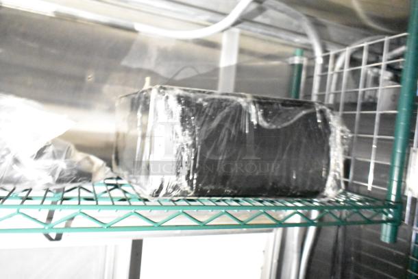 Alt text: Mobile kitchen trailer interior shelf with wrapped items, featuring a metal storage rack.