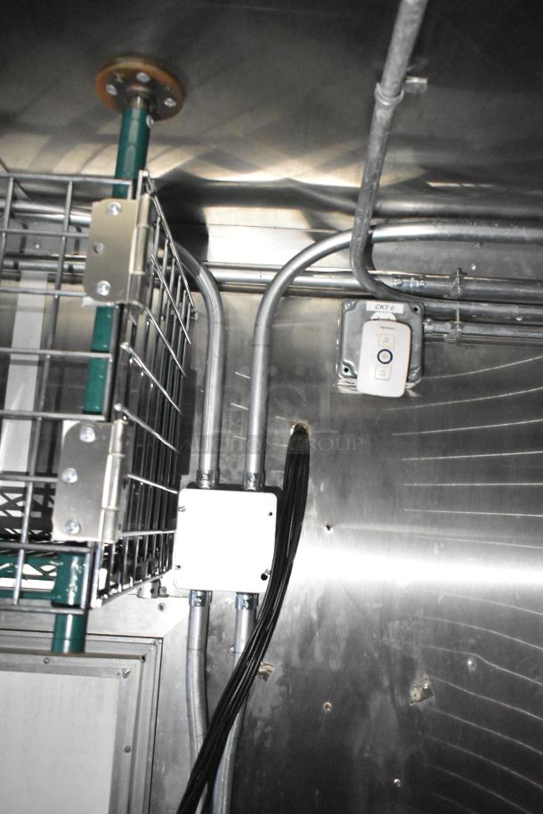 Interior view of a mobile kitchen trailer showing wiring and metal fixtures, indicating CaptiveAire hood system.