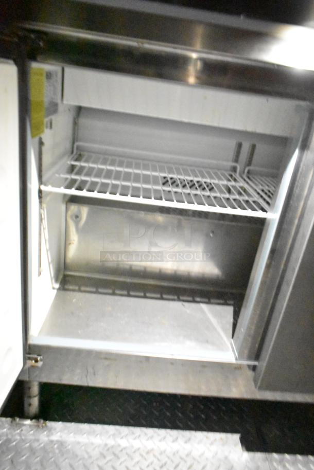 Mobile kitchen interior, featuring storage shelves and stainless steel construction. Ideal for commercial use.