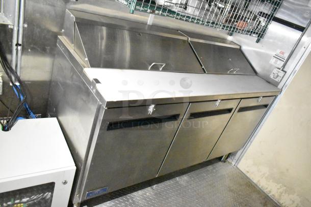 Mobile kitchen trailer interior with stainless steel Arctic Air prep tables, coolers, and freezer. Clean condition.