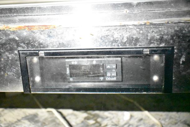 Alt text: Dixell temperature controller on mobile kitchen equipment, visible wear on metal surface above.