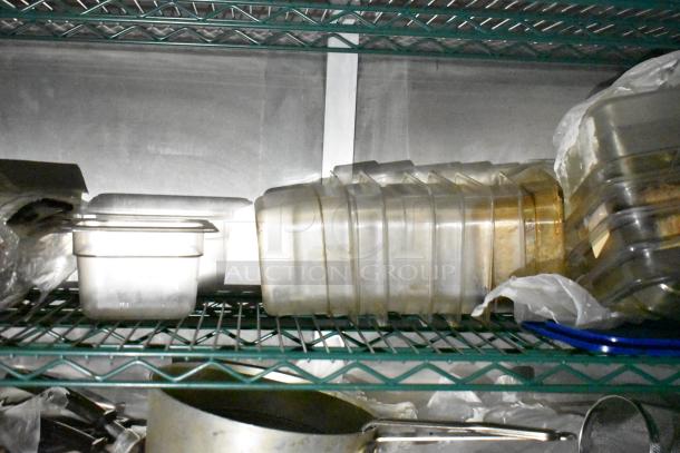 Mobile kitchen trailer interior with shelves, featuring food storage containers, metal pots, and kitchen utensils.