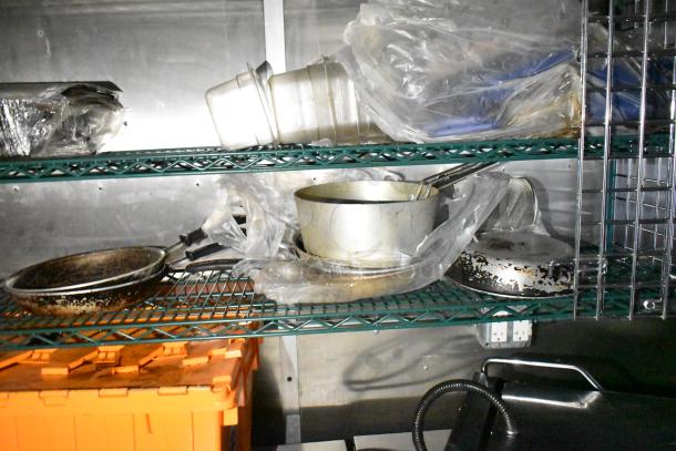 Mobile kitchen trailer with CaptiveAire hood, Pitco fryers, Arctic Air prep tables, fry pans, pots, and kitchen tools visible.