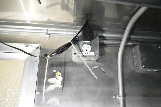 Electrical outlet labeled "CKT 13" inside a mobile kitchen trailer, with visible wiring and conduit.