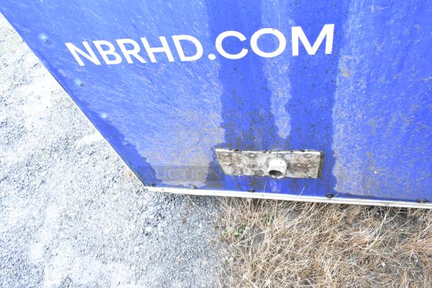 Mobile kitchen trailer surface with visible wear and "NBRHD.COM" label. Outdoor setting, showing dirt and rust marks.