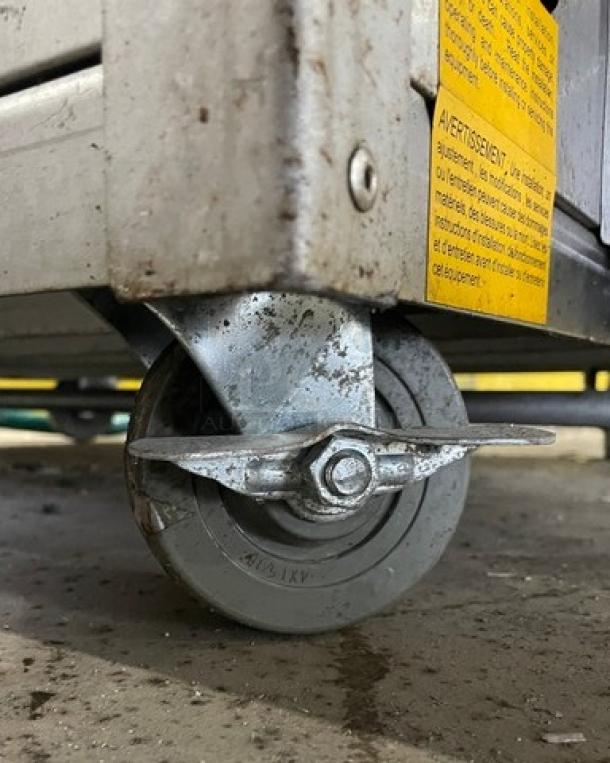 Old Hickory Model N14G rotisserie oven caster. Condition shows wear. Stainless steel frame, yellow safety label visible.