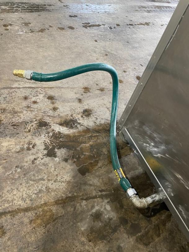 Old Hickory N14G rotisserie oven gas connection, stainless steel, shows wear, attached flexible hose, commercial use.