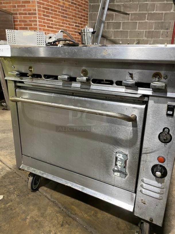 Montague Commercial Stainless Steel Gas 6-Burner Range/Convection Oven Combo on casters, visible controls, pre-owned condition.