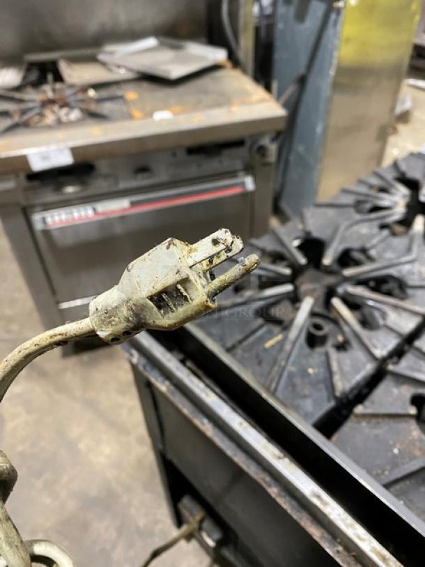 Montague stainless steel 6-burner range/convection oven combo on casters. Features gas power, durable build, signs of wear.