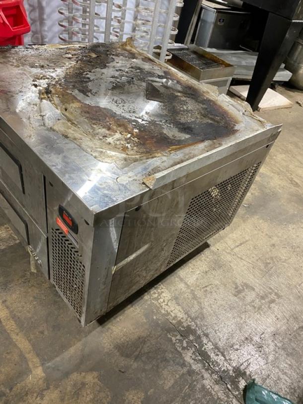 Turbo Air stainless steel 2-drawer refrigerated chef base on casters, worn and rusted top, commercial use item.