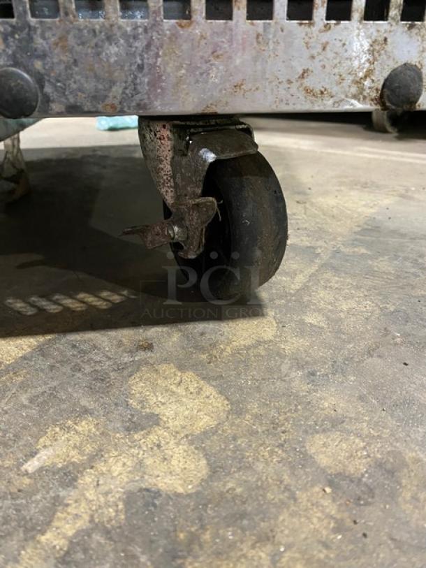 Turbo Air stainless steel 2-drawer refrigerated chef base on caster wheel, showing some wear and rust.