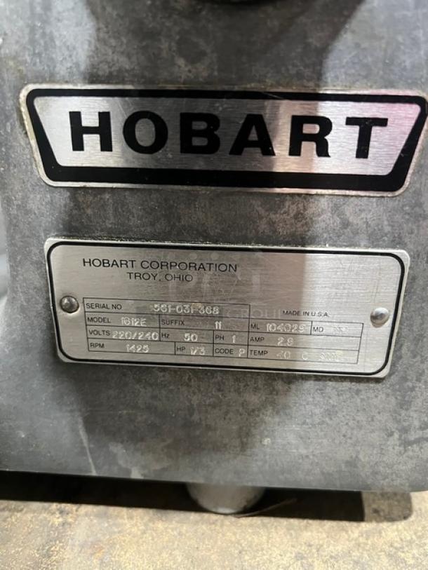 Hobart 1612E commercial meat slicer, serial 561-031-368, 220/240V, 1 phase, in fair condition with visible metal casing and labels.