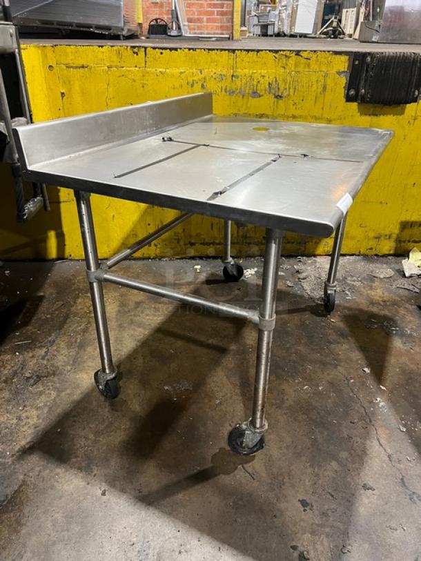 Commercial stainless steel worktop table with up-turned backsplash, on casters. Suitable for kitchens. Good condition.