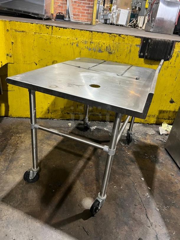 Commercial stainless steel worktop table with up-turned backsplash on casters, used condition, ideal for kitchen use.
