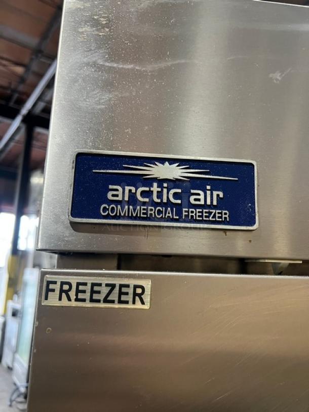 Arctic Air AF23 commercial stainless steel freezer with single door, poly-coated wire rack; model and "FREEZER" labels visible.