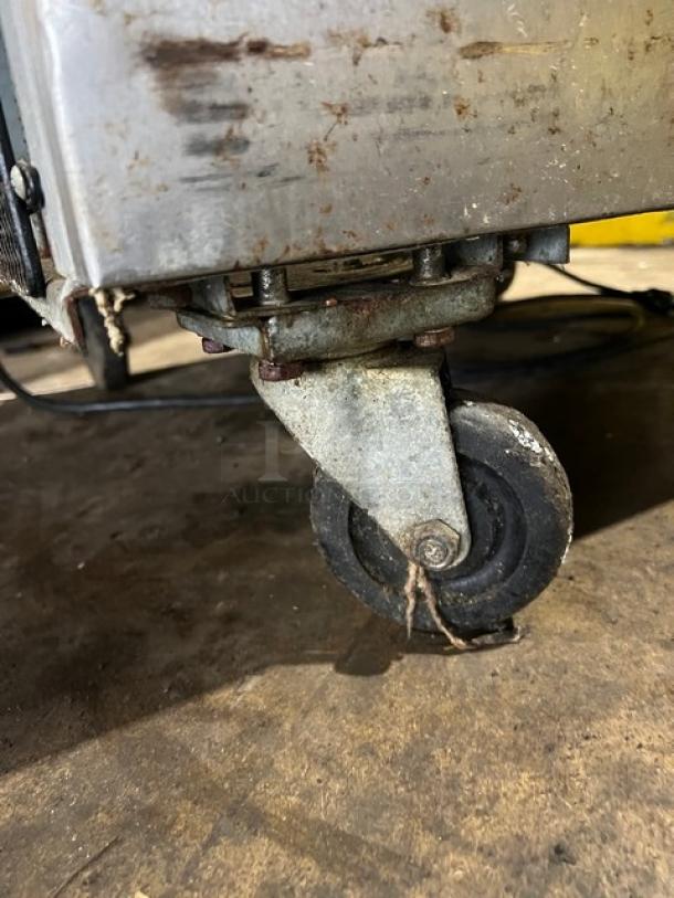 Arctic Air AF23 stainless steel reach-in freezer with poly-coated wired rack, on casters, showing wear. Serial: 6092726.