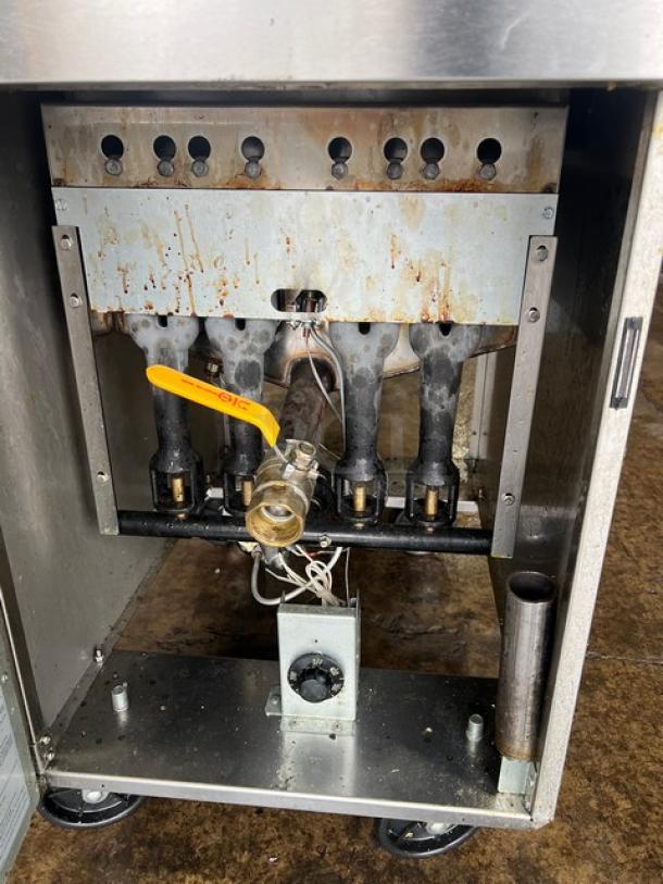 Asber AEF75NGGAS stainless steel deep fat fryer, natural gas, with casters, backsplash, and basket hanger, interior view.