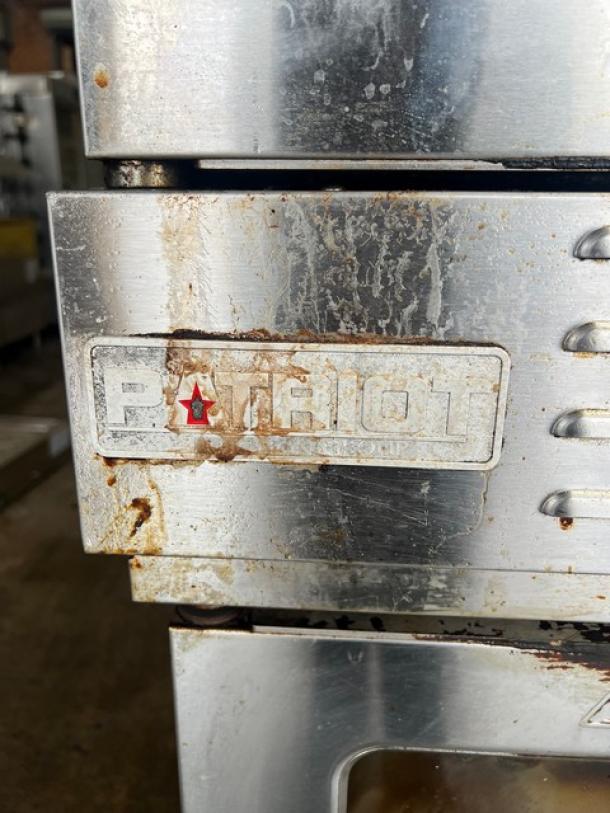 Patriot stainless steel convection oven, Model FMCOF-54/NG, natural gas, on casters, shows wear, thermostatic controls.