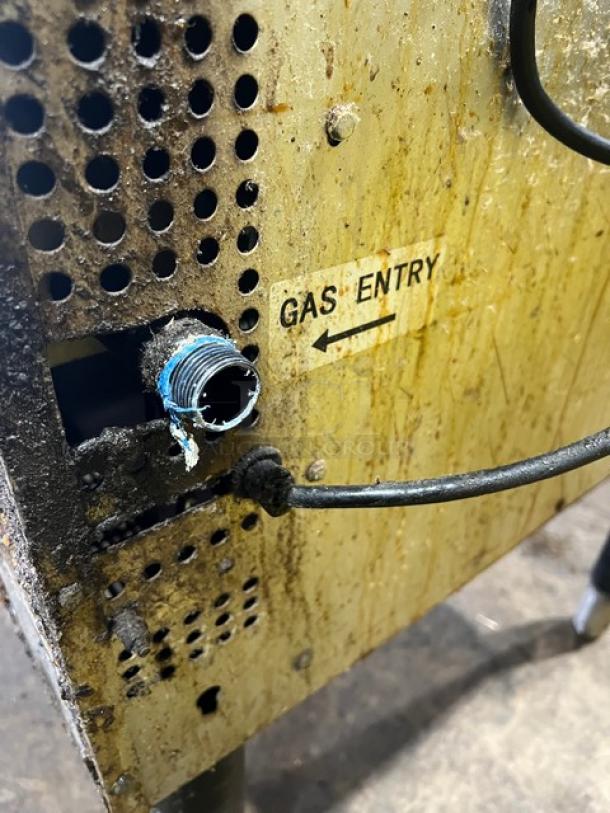 Cpg commercial stainless steel gas-powered convection oven gas entry port, with visible wear, thermostatic controls, wired rack, legs.