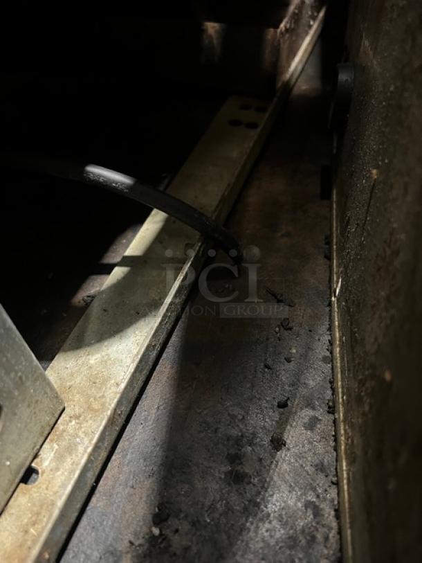 Alt text: Close-up of the interior details of a Continental stainless steel refrigerated prep table, showing wiring and metal components.