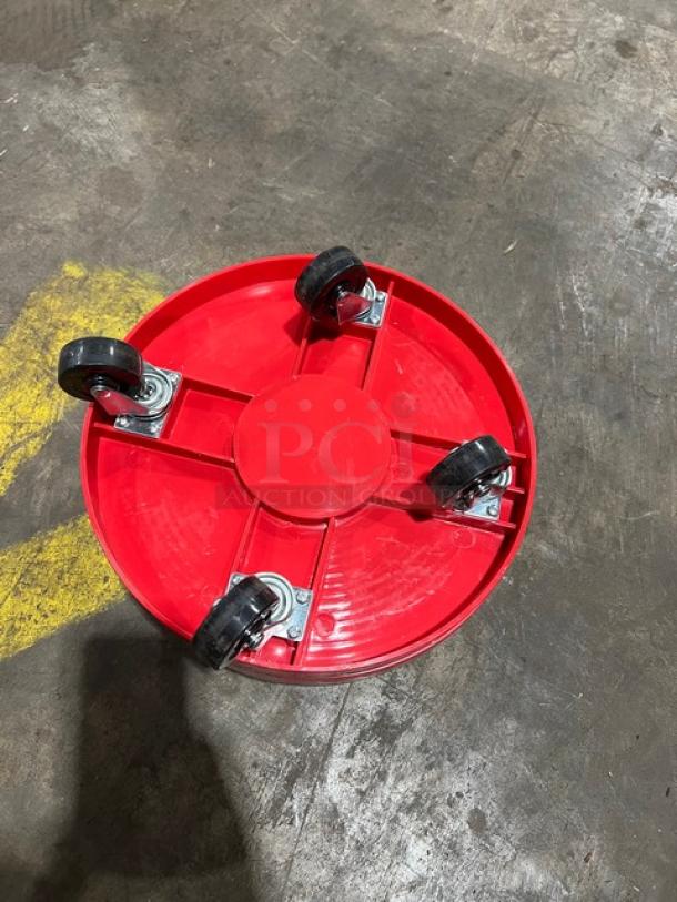 Red round multi-purpose dolly with four swivel casters, new condition, ideal for commercial use.