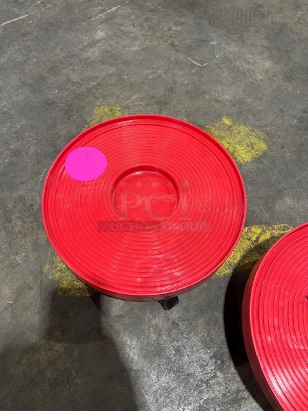 New commercial red round multi-purpose dolly, mint condition, with a prominent pink sticker visible on the surface.