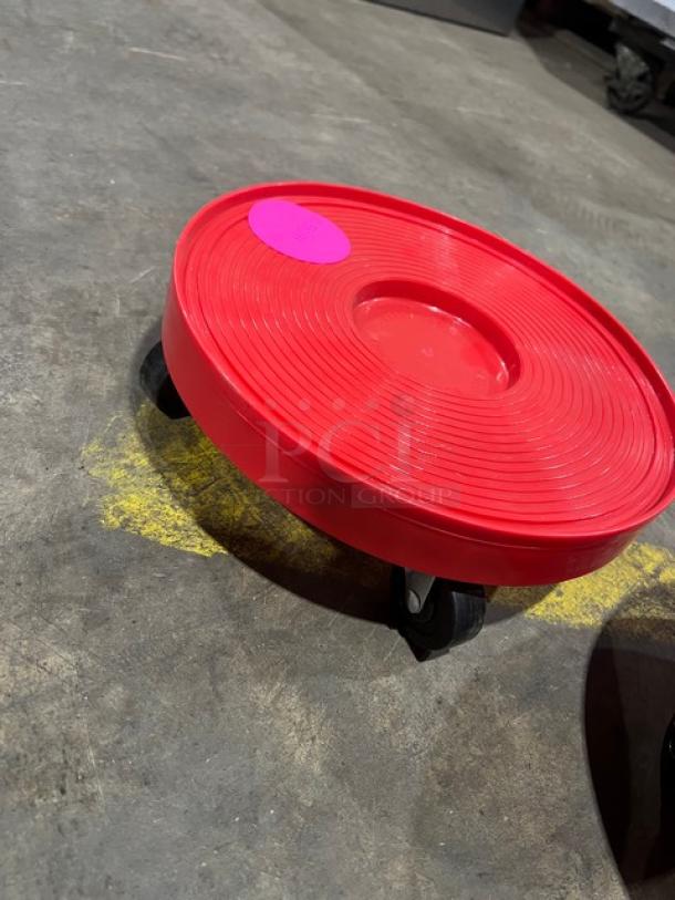 New commercial red round multi-purpose dolly, pristine condition, four swivel casters, circular textured surface, pink label.