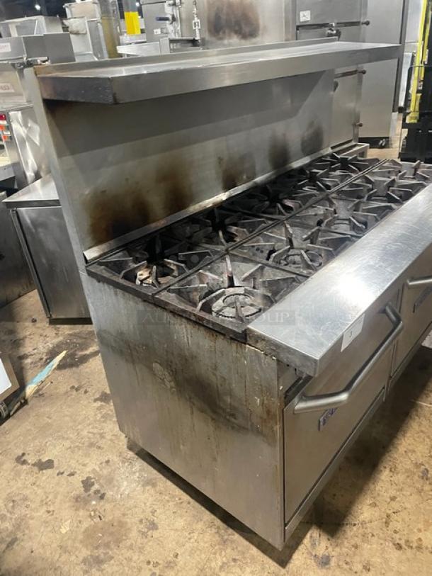 American Range stainless steel gas-powered 6-burner range with raised flat-griddle, double oven, broiler, and cheese melter; on legs.