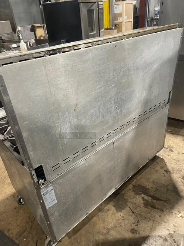 American Range commercial stainless steel gas range with 6 burners, flat griddle, double oven, broiler, and backsplash.