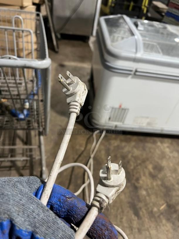 AHT MALTA 185 commercial chest freezer with double sliding doors, 120V 1 Phase, visible power cords, model and serial labels.