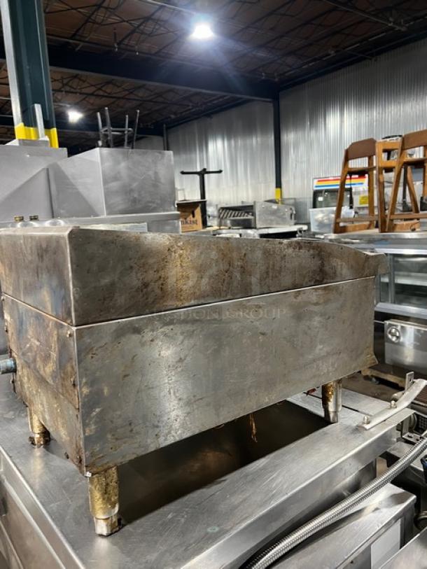 CPG natural gas 15" countertop char broiler grill on legs. Used condition with visible wear and industrial setting.